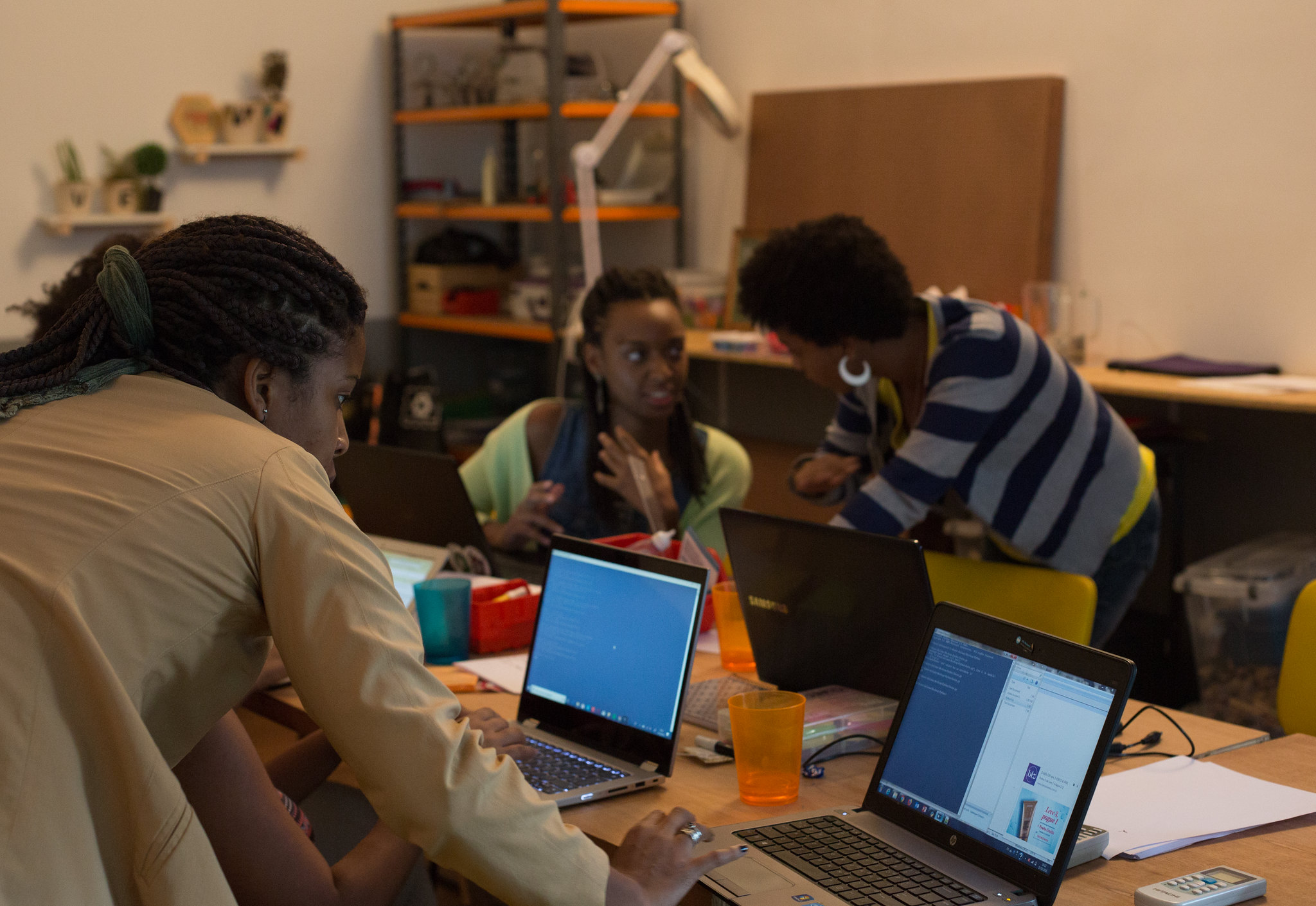 People working on laptops around a desk.