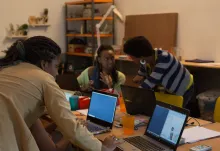 People working on laptops around a desk. Image licence: CC BY-SA